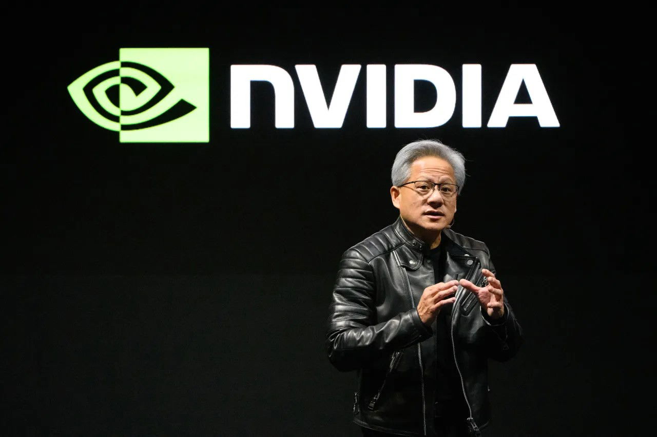 TechDogs-"Nvidia’s Open-Source Ambitions: SchedMD And Nemotron 3"-"Nvidia's CEO Jensen Huang Presenting During A Company Keynote With The Nvidia Logo Displayed On Screen Behind Him"