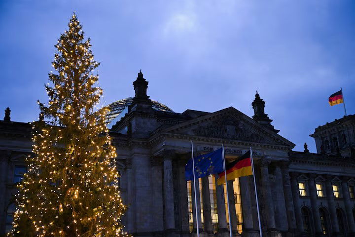 TechDogs-"Bundestag Breach During Zelenskyy’s Berlin Visit"-"The Reichstag Building In Berlin, Home To The German Bundestag, Illuminated With A Christmas Tree And EU And German Flags At Dusk"