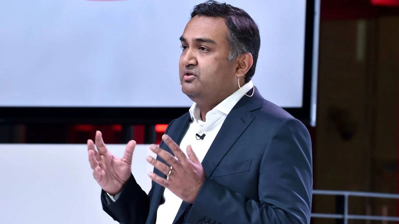 TechDogs-"YouTube Will Stream The Oscars Exclusively Starting In 2029"-"YouTube's CEO Neal Mohan Speaking On Stage With Headset Microphone During Industry Event Presentation"