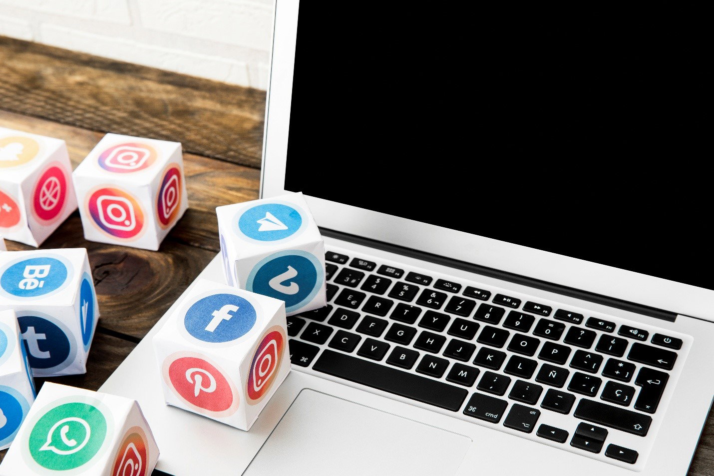 TechDogs-"Creators Rethink Reach As Algorithms Take Over Social Media"-"An Image Showing A Laptop Besides Blocks With Social Media Platforms Icons" TechDogs-"Creators Rethink Reach As Algorithms Take Over Social Media"-"An Image Showing A Laptop Besides Blocks With Social Media Platforms Icons"