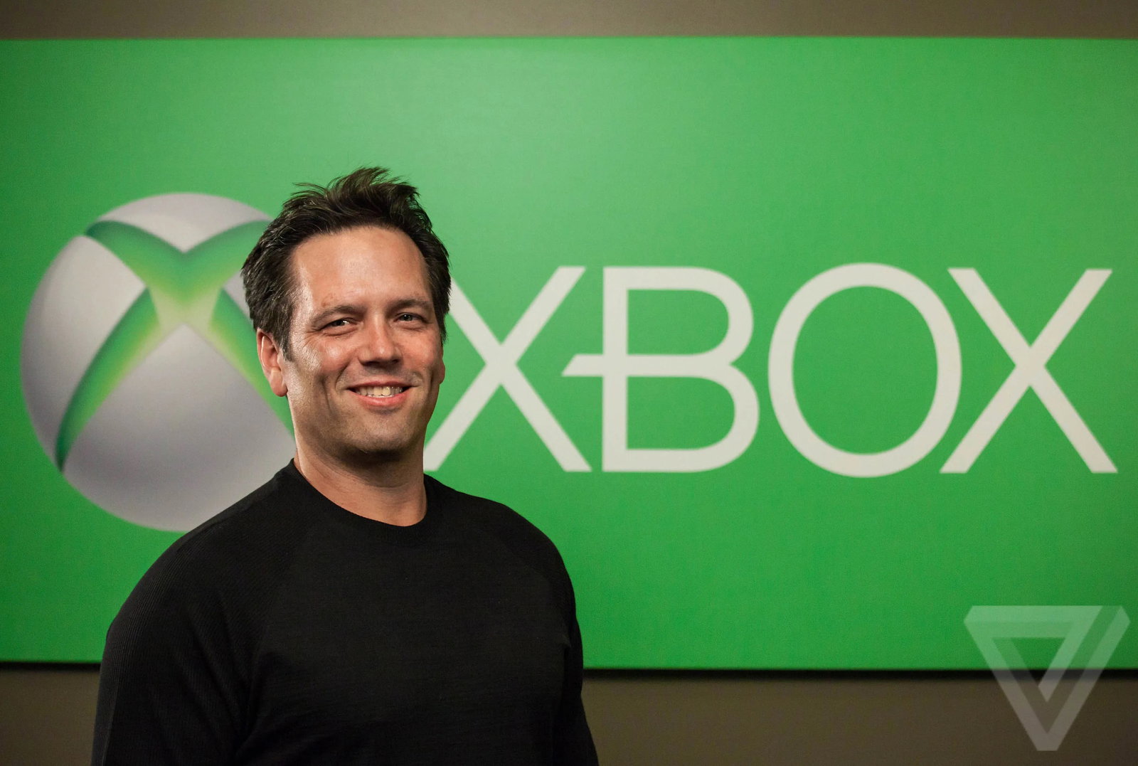 TechDogs-"Xbox CEO Phil Spencer Standing In Front Of The Xbox Logo, Representing Leadership In Console, PC, And Cloud Gaming Strategy"