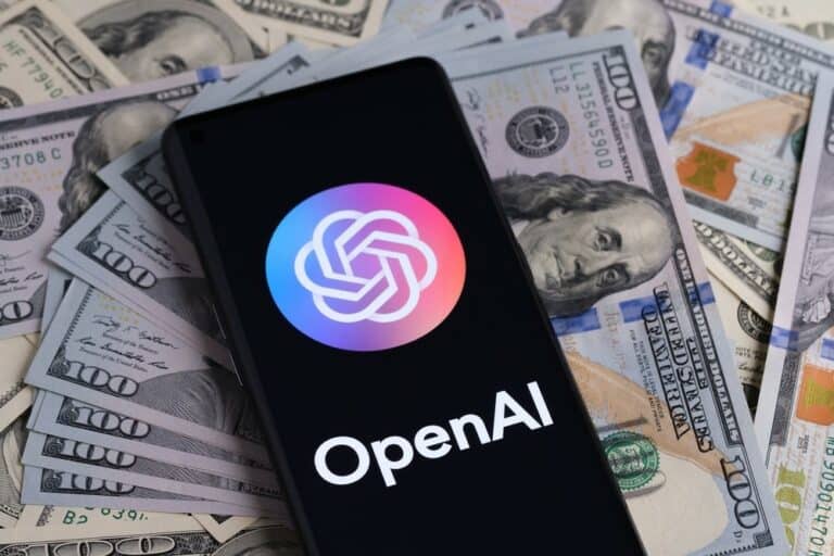 TechDogs-"An Image Of OpenAI's Logo On A Smartphone On A Pile Of Money"