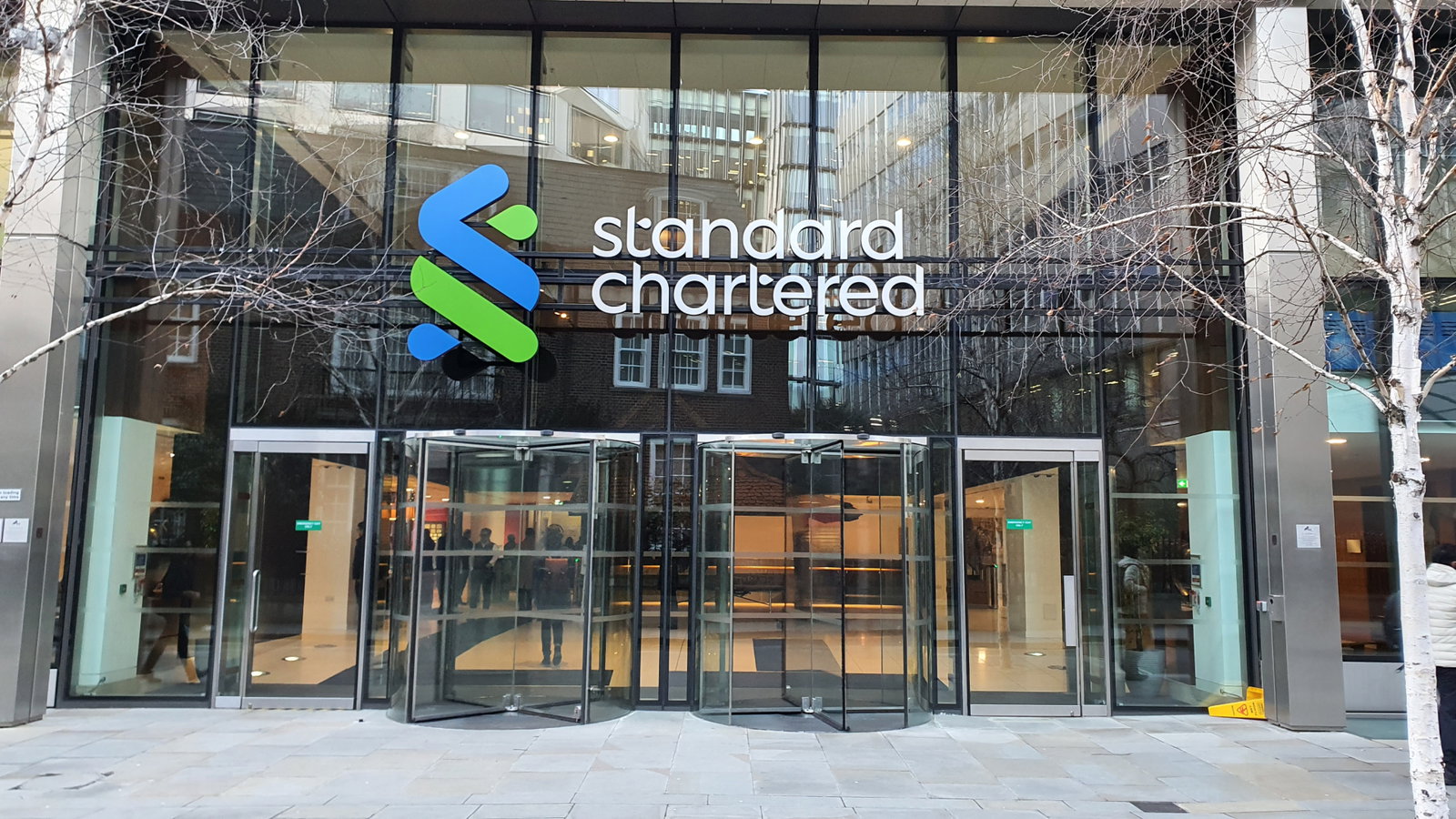 TechDogs-"An Image Of A Standard Chartered Office Building With Its Logo"